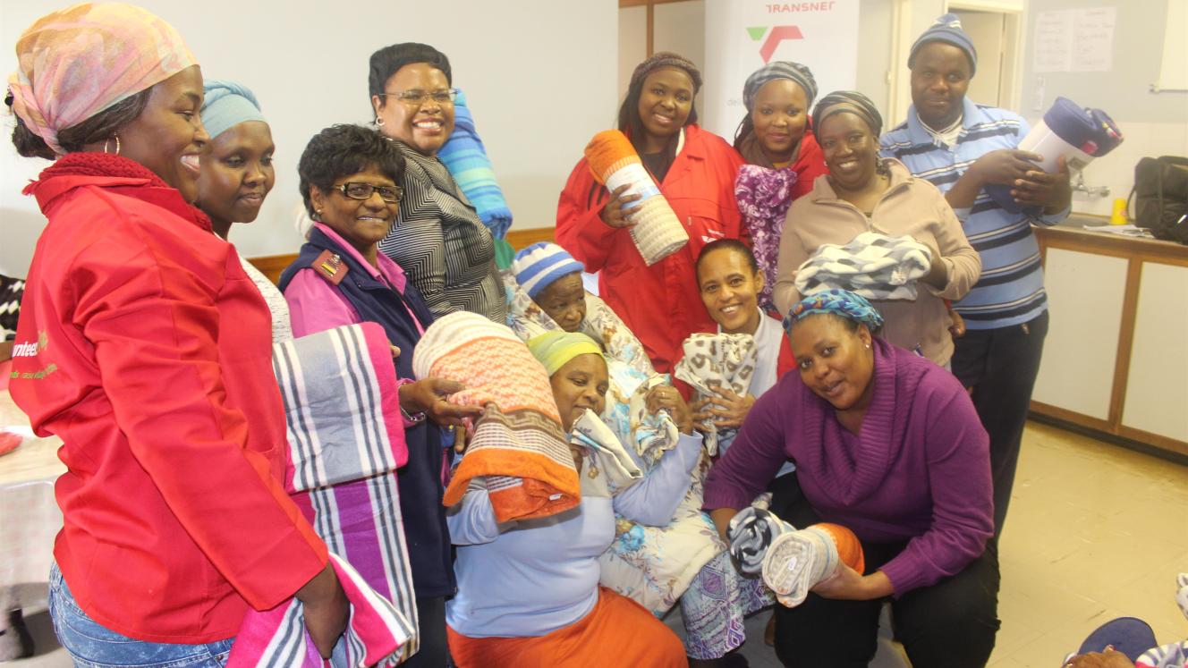 The Eastern Cape regional corporate affairs manager for TPT, Sindie Ndwalaza (pictured in front), handing over some of the blankets.
