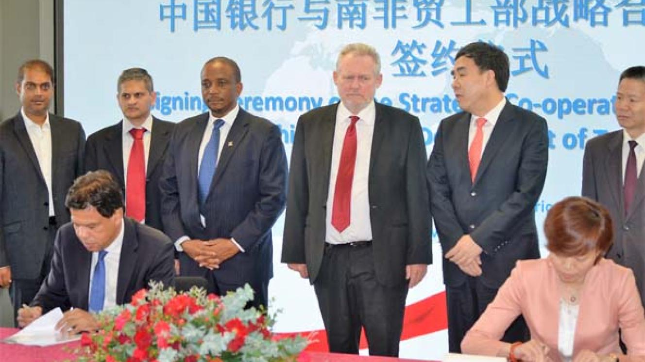 Minister of trade and industry, Dr Rob Davies, and dignitaries observe as dti director-general, Lionel October, and BOC’s general manager of the financial solutions department, Ren Li, sign the MoU. 
