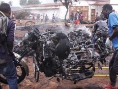 Bystanders carry off an incinerated motorcycle following a fuel tanker blaze in Tanzania over the weekend. 