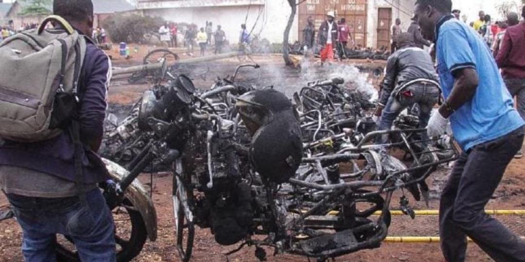 Bystanders carry off an incinerated motorcycle following a fuel tanker blaze in Tanzania over the weekend. 