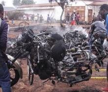 Bystanders carry off an incinerated motorcycle following a fuel tanker blaze in Tanzania over the weekend. 